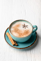coffee with milk in a ceramic blue cup on a wooden background. Place for text, top view.