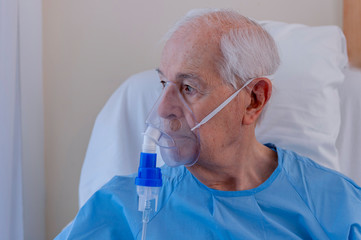 Elderly man hospitalized, with an oxygen mask