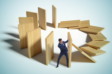 Businessman in domino effect concept