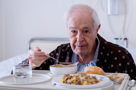 Elderly man hospitalized, eating in the room