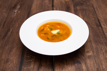A plate of Minestrone soup in a white plate on a wooden table. Traditional Italian food, restaurant...