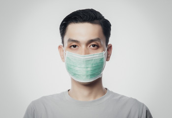 Closeup Young Asian Man wearing hygienic mask to prevent infection, 2019-nCoV or coronavirus. Airborne respiratory illness such as pm 2.5 fighting and flu isolated on white background.
