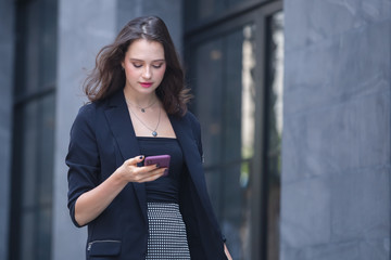Fototapeta premium businesswomen using smartphone walking outside office in relax time.