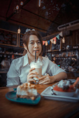 Young female student eating cake in a coffee shop