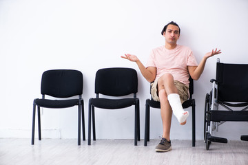 Obraz premium Young injured man waiting for his turn in hospital hall