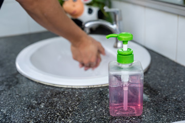 Man washes his hands with liquid soap in the sink