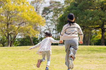 春の公園で遊んでいる可愛い子供姉妹