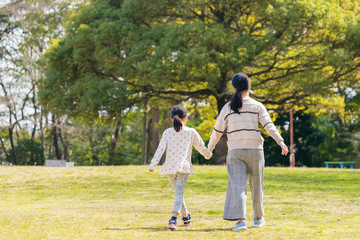 Fototapeta premium 春の公園で散歩している子供姉妹
