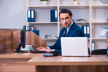 Fototapeta na wymiar Young handsome businessman working in the office