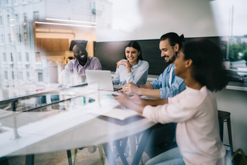 Smiling coworkers sitting at table in office