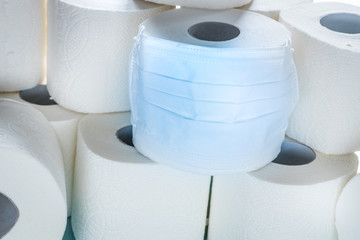roll of toilet paper in an anti-virus mask.  Symbol of purchasing goods during the Coronavirus...