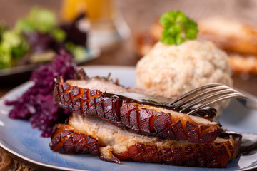 portion of fresh roasted pork on a blue plate