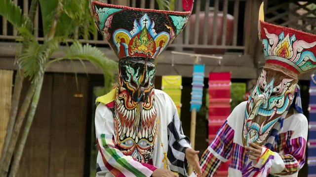 The  people in Thailand on phitakhon ghost festival holiday carnival wearing colorful custume clothes wearing hand paint mask dancing on street with happiness.  