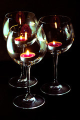 three candels tealights in wine glasses