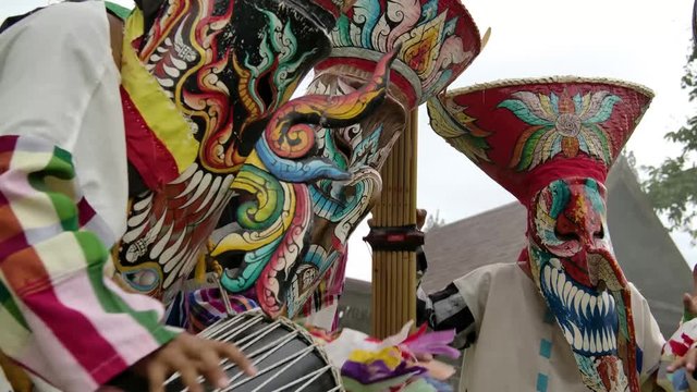 The  people in Thailand on phitakhon ghost festival holiday carnival wearing colorful custume clothes wearing hand paint mask dancing on street with happiness.  