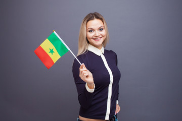 Immigration and the study of foreign languages, concept. A young smiling woman with a Senegal flag...