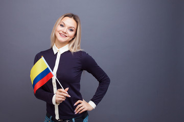 Immigration and the study of foreign languages, concept. A young smiling woman with a Colombia flag...