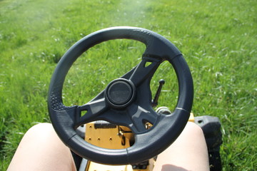 Fototapeta na wymiar Steering wheel of a lawn tractor cutting grass