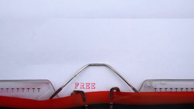 Freedom - word printed on an old typewriter in red letters, close up. vintage inscription