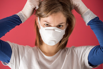 nurse surgical gloves puts on molded mask to prevent coronavirus infections and prevent the spread of the world pandemic