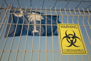 Biohazard coronavirus sign on the barbed wire fence near flag of South Carolina. COVID-19 quarantine related 3D rendering