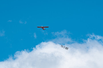 Fototapeta na wymiar Hamburg, Germany - March 21, 2020; #StayAtHome sign pulled by an airplane flying above the city centre during the 2020 Coronavirus pandemic. 