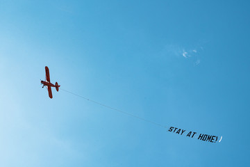 Hamburg, Germany - March 21, 2020; #StayAtHome sign pulled by an airplane flying above the city centre during the 2020 Coronavirus pandemic. 