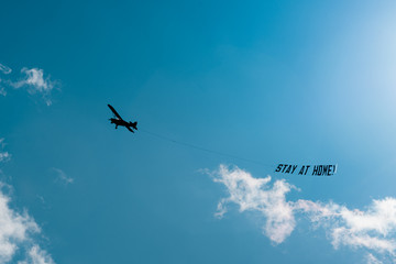 Hamburg, Germany - March 21, 2020; #StayAtHome sign pulled by an airplane flying above the city centre during the 2020 Coronavirus pandemic. 