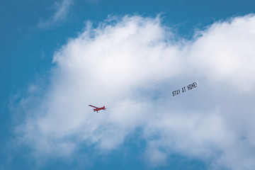 Hamburg, Germany - March 21, 2020; #StayAtHome sign pulled by an airplane flying above the city centre during the 2020 Coronavirus pandemic. 