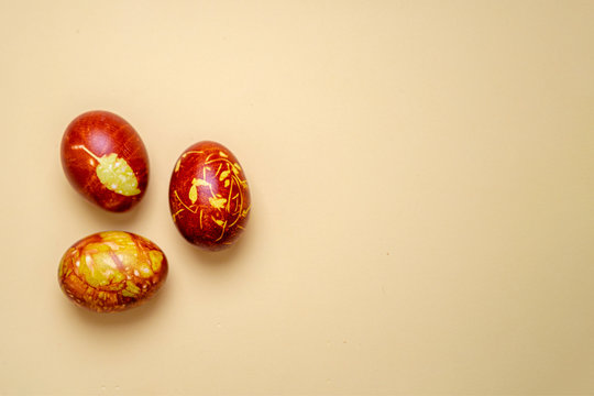 Chicken eggs colored with old-fashioned natural method by onion husks isolated on light brown. Topview of brown eggs with different natural patterns with copyspace. Traditional Easter concept