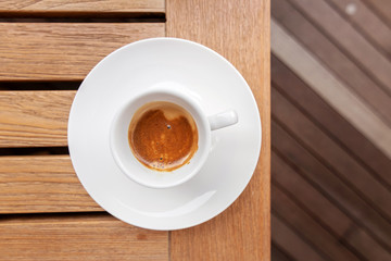 Cup of espresso coffee on a wooden table background. Top view