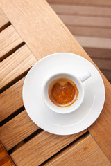 Cup of espresso coffee on a wooden table background. Top view