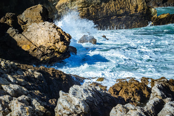 Amazing wave breaking against the stones close up in San Vicente de la Barquera, Cantabria, Spain.