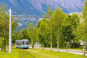 Modern tram on the streets of Grenoble city. In 1987, Grenoble became the second French city to...
