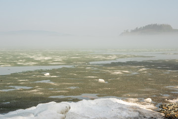 Morning fog on the lake, sunrise, lake in ice, ice is melting on the lake