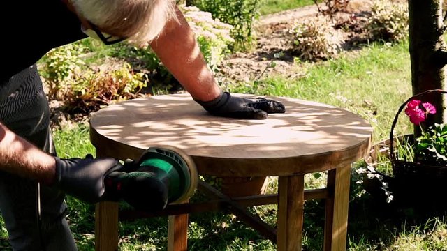 Mand grinding old table in the garden, 120fps