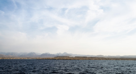 rocky coast of the Red Sea and.blue sky with clouds