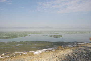 Morning fog on the lake, sunrise, lake in ice, ice is melting on the lake