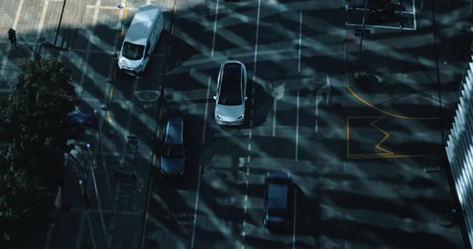 White Tesla model X driving on the street. Urban city buildings visible.  Filmed with dji inspire two drone.