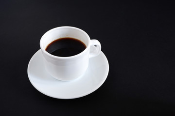 Set: a mug, a saucer. On black background.