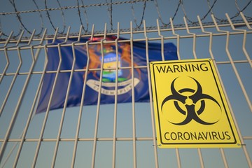 Biohazard coronavirus sign on the barbed wire fence near flag of Michigan. COVID-19 quarantine related 3D rendering
