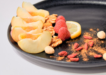 Healthy and colourful breakfast with fresh fruit, dried fruit and cinnamon