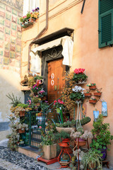 Finalborgo (SV), Italy - December 12, 2017: An old doorway whith a lot of flowers in Finalborgo village, Finale Ligure, Liguria, Italy