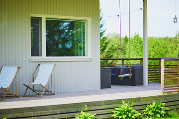 Two chaise longues and a swing on the porch