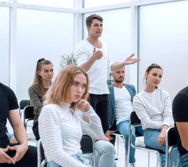 young man asks a question at a business seminar