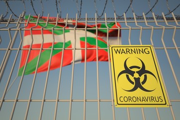 Coronavirus warning sign on the barbed wire fence near flag of Basque Country, an autonomous community in Spain. COVID-19 quarantine related 3D rendering