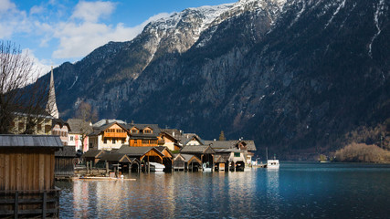 Naklejka premium Traditional wooden boat houses in Hallstatt - mountain village at Hallstaetter Lake, Salzkammergut. UNESCO world heritage site, old European architecture.