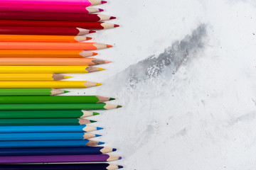 Colored pencils on a white stone table