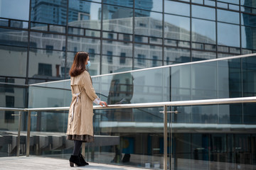 Obraz premium A Chinese woman wearing face mask is quarantined by glass walls.