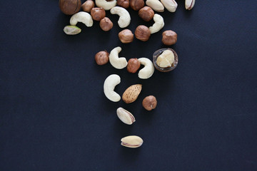Nuts on black background, top view with copyspace. Assorted mixed nuts  isolated on dark table.
